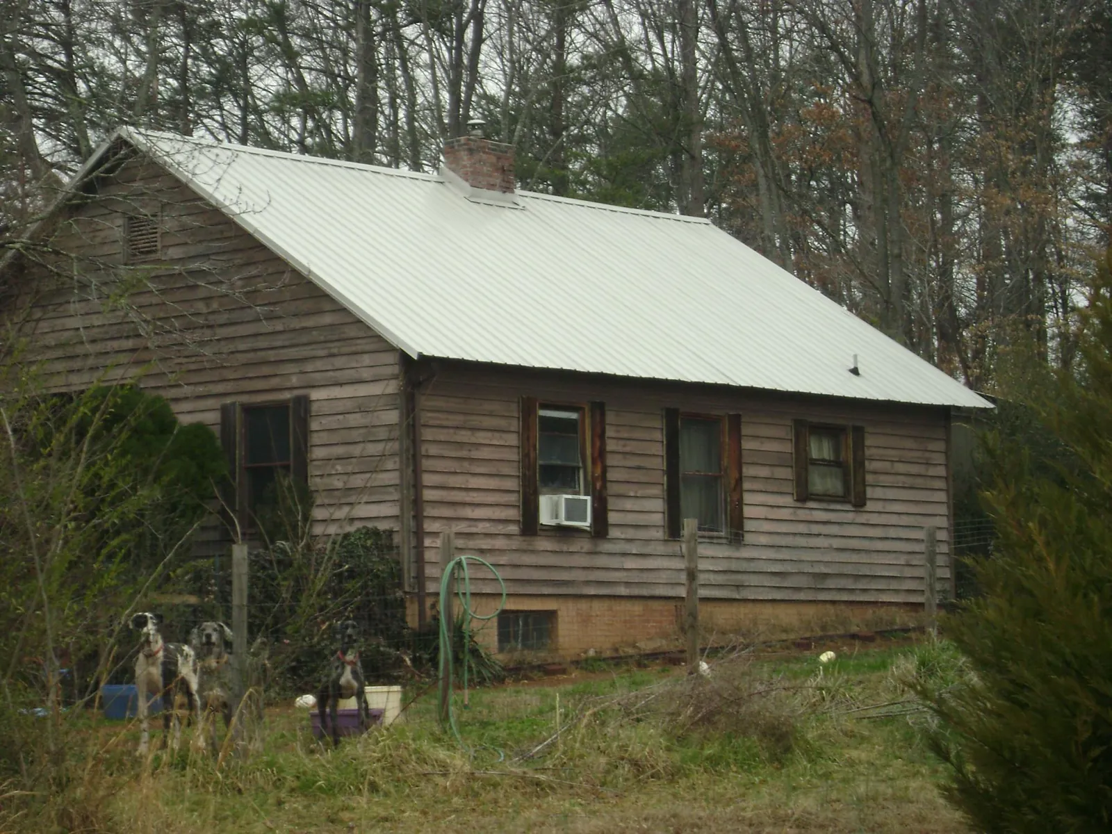 White metal roof on an old wood sided farmhouse in Morrisville